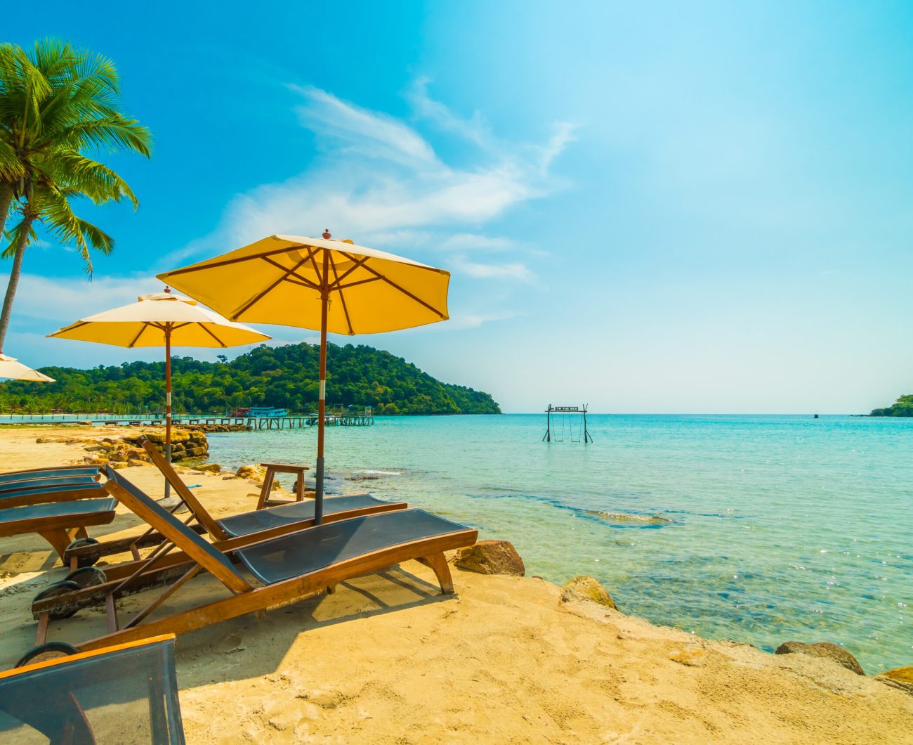 Umbrella and chair on the Beautiful tropical beach and sea with coconut palm tree in paradise island for travel and vacation